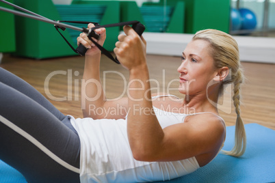Side view of woman using resistance band in fitness studio