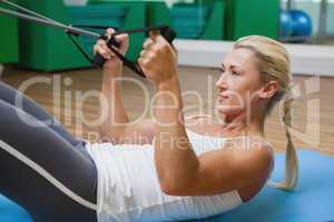Side view of woman using resistance band in fitness studio