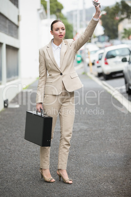 Young businesswoman hailing a cab