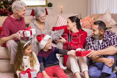 Multi generation family exchanging presents on sofa