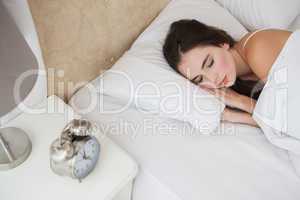 Pretty brunette lying in bed sleeping