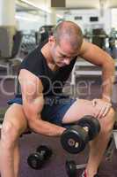 Young man exercising with dumbbell in gym