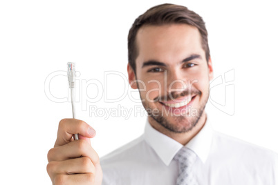 Happy businessman holding white cable