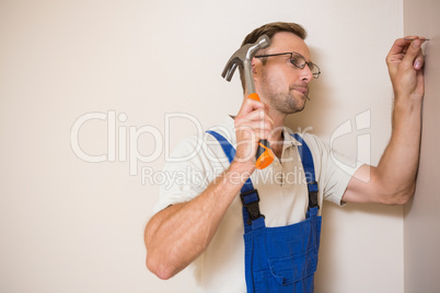 Handyman hammering nail in wall