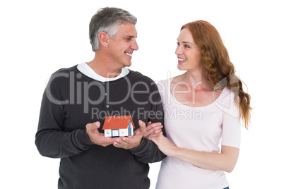 Casual couple holding small house