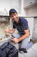 Plumber fixing under the sink