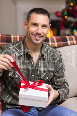 Happy man opening a gift on christmas day