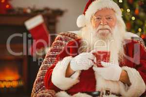 Smiling santa claus holding a mug