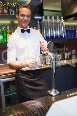 Handsome barkeeper pulling a pint of beer