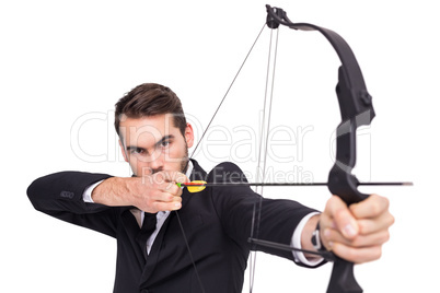 Smart businessman practicing archery looking at camera