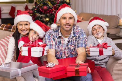 Festive family on the couch offering gifts