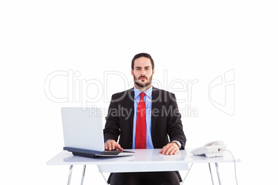 Unsmiling businessman sitting at desk