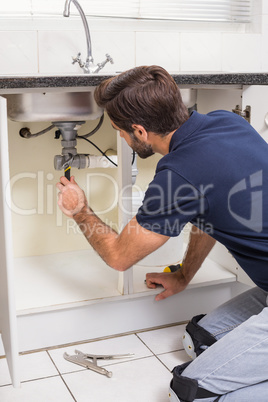 Plumber fixing under the sink