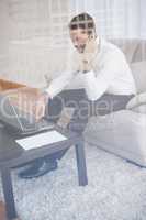 Businessman working on his couch seen through glass