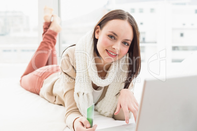 Pretty brunette using laptop on bed