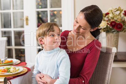 Smiling mother with her son sitting on lap
