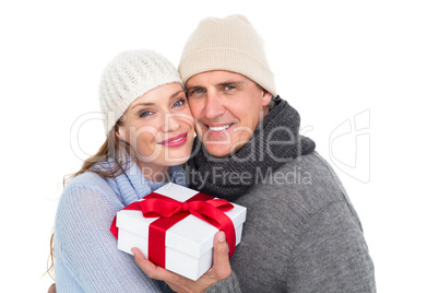 Casual couple in warm clothing holding gift