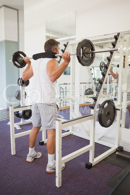 Fit man lifting heavy barbell