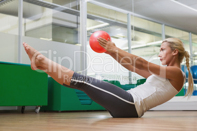 Side view of woman in boat pose at fitness studio