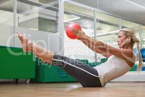 Side view of woman in boat pose at fitness studio