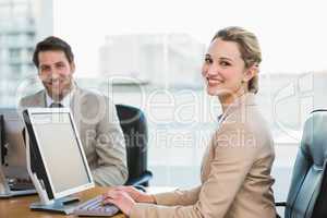 Two young business people using computer