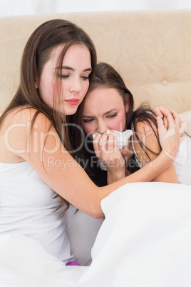 Brunette comforting her crying friend