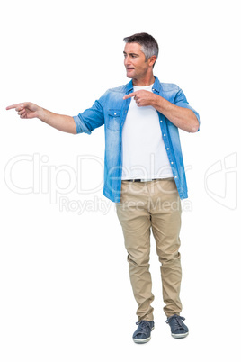 Smiling man in casual clothes pointing