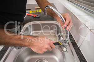 Plumber fixing the sink with wrench
