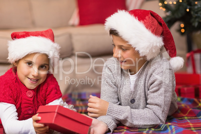 Brother and sister lying on the cover holding a gift