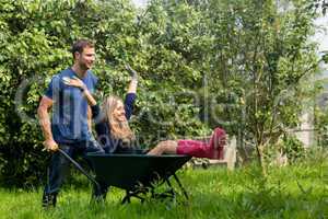 Man pushing his girlfriend in a wheelbarrow