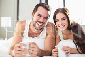 Young couple having coffee in bed