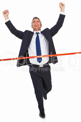 Businessman crossing finish line and cheering