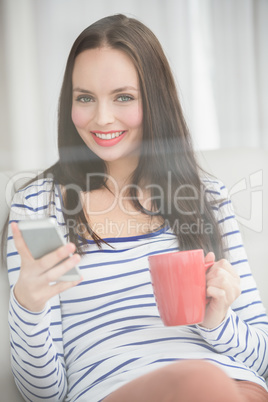 Pretty brunette sending text on the couch