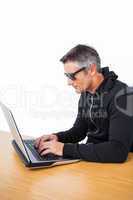 Man with sunglasses typing on laptop