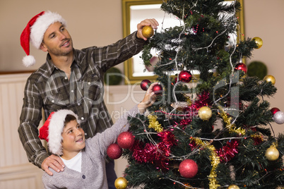 Son and dad decorating the christmas tree