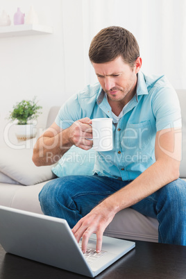 Concentrate man using his laptop at home