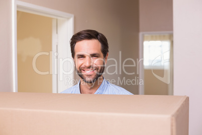 Happy man carrying moving box