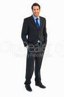 Smiling young businessman with hands in pockets