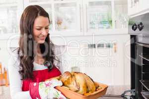 Happy woman holding roast turkey