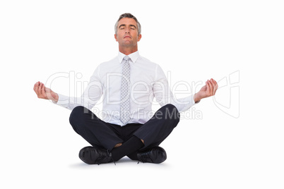 Peaceful businessman sitting in lotus pose