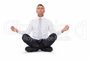 Peaceful businessman sitting in lotus pose