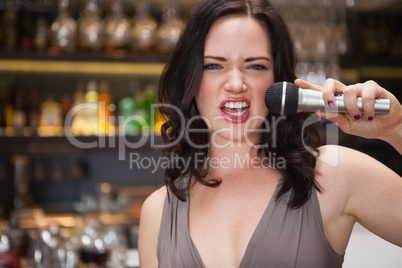 Pretty brunette singing with her microphone