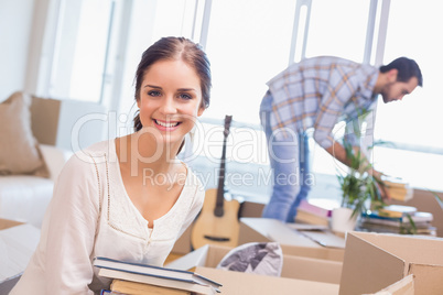 Cute couple unpacking cardboard boxes