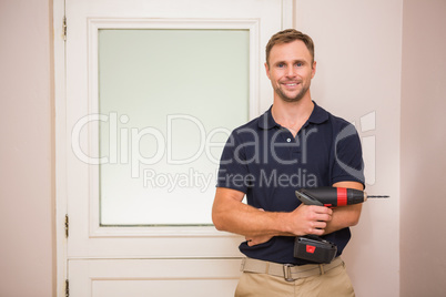 Construction worker holding power tool with arms crossed