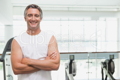 Fit man smiling at camera in fitness studio