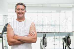 Fit man smiling at camera in fitness studio