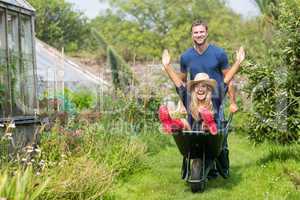 Man pushing his girlfriend in a wheelbarrow