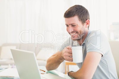 Casual businessman holding a mug at desk