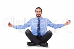 Businessman in suit sitting in lotus pose