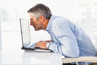 Businessman looking closely at the laptop